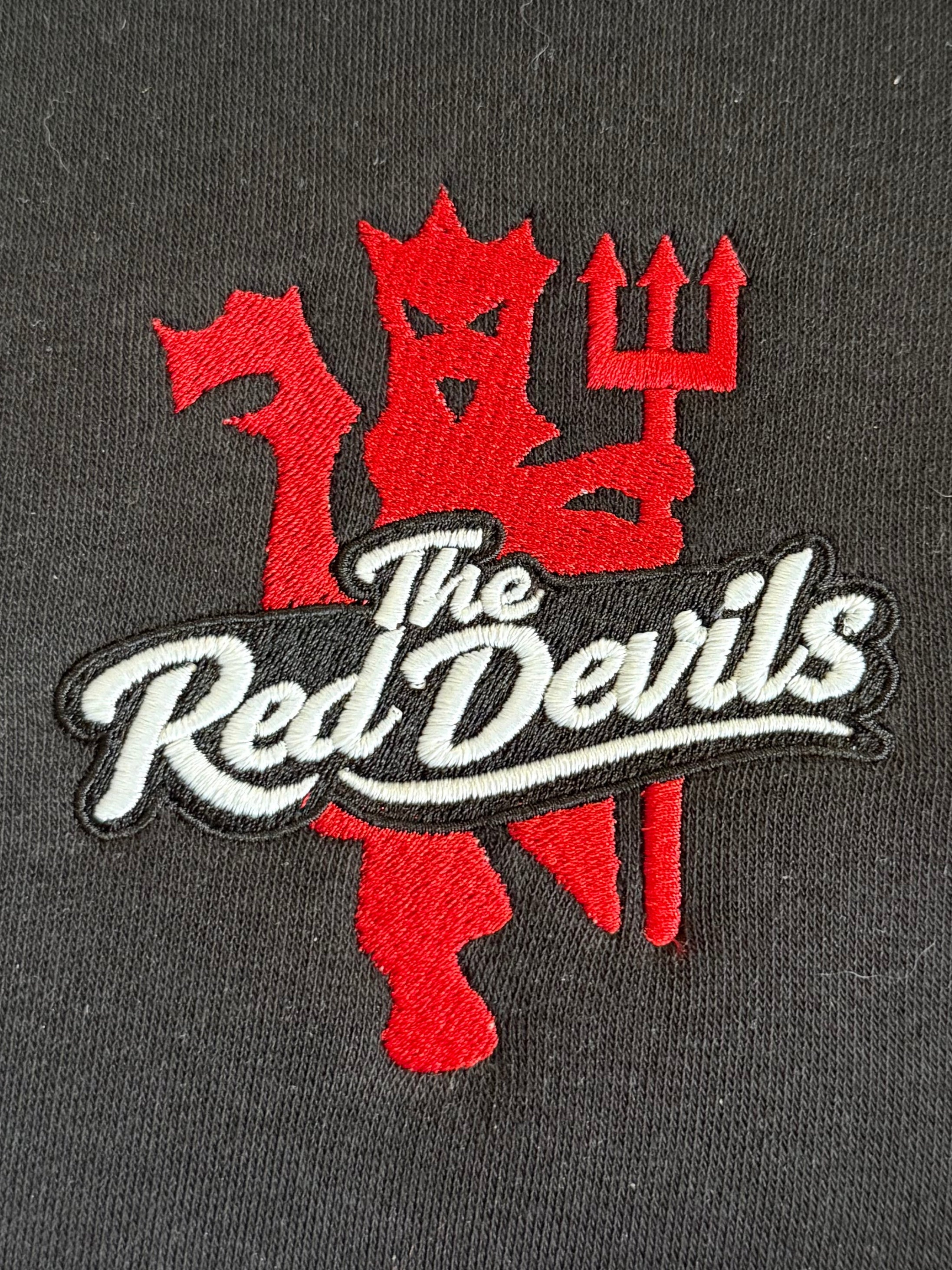 Embroidered patch of MUFC With  'The Red Devils' Strike through on.